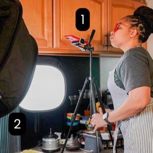 chef maika looking into the phone's camera on a tripod on top of the kitchen counter.