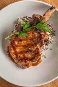 Sweet spicy tamarind glazed grilled thick porkchops on the bone on coleslaw dressing.